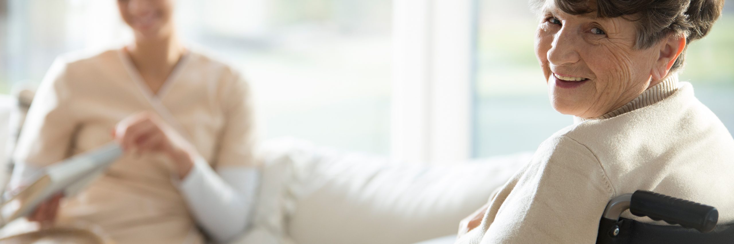 Ikääntynyt nainen kääntyneenä kameraa kohti.