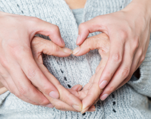 Kädet käsissä tekevät yhdessä sydänkuvion.